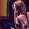 Fit woman lifting weights, showcasing strength in a gym environment.